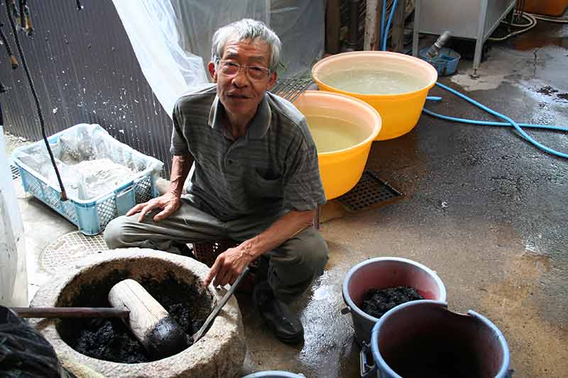 Un homme japonais devant des cuves de teinture textile - photo Delphine TALBOT